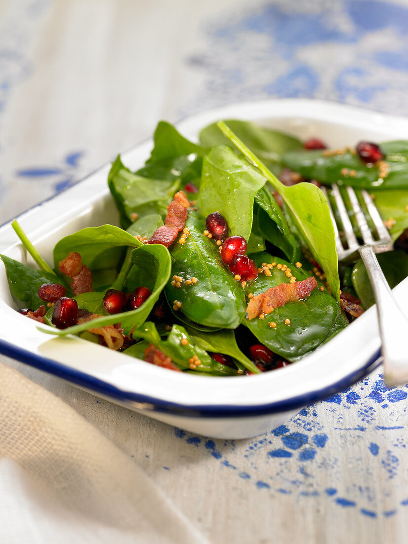 Raw spinach, bacon and pomegrante seed salad