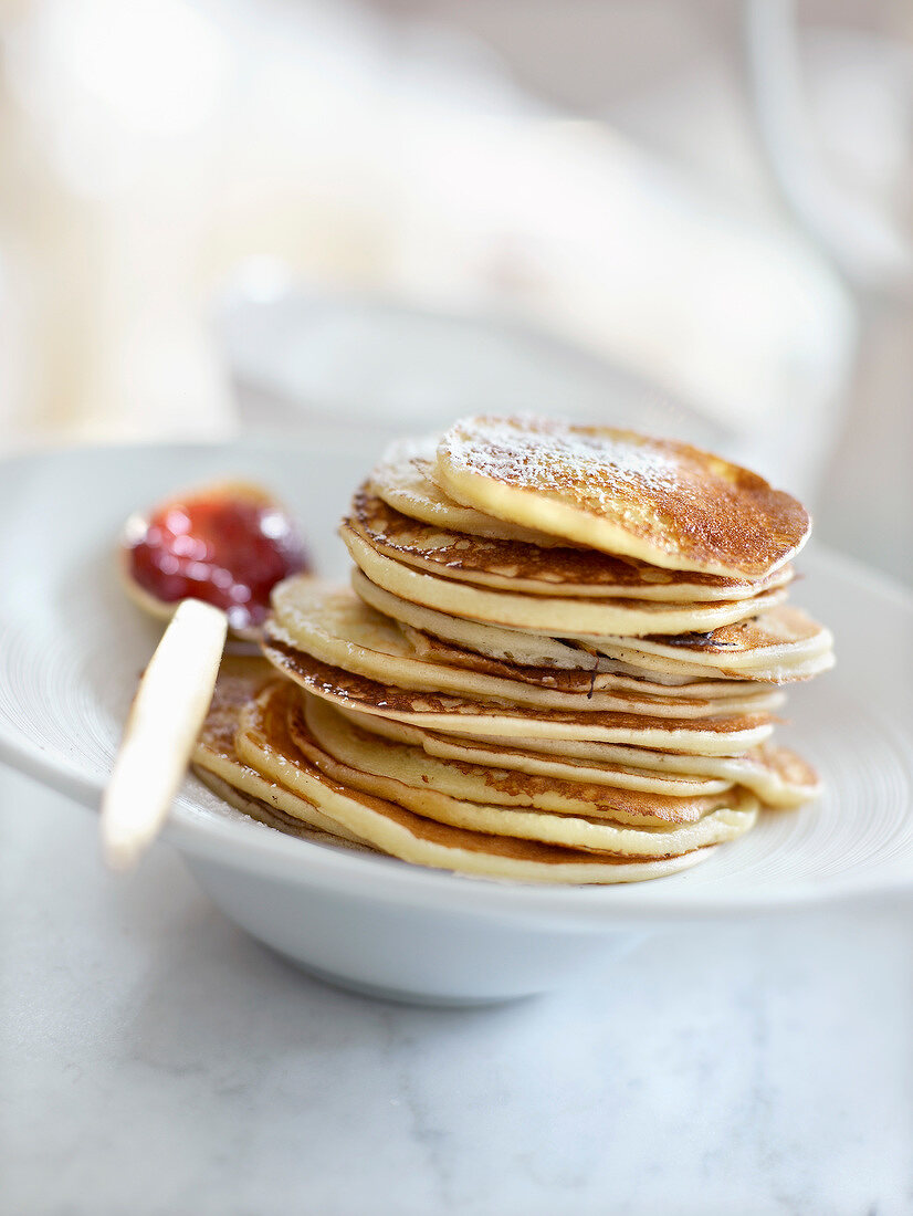 Stacked pancakes and a spoonful of summer fruit jam