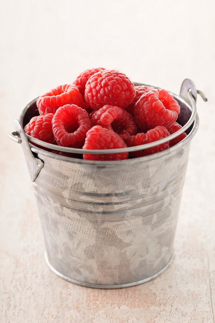 Small metal bucket of raspberries