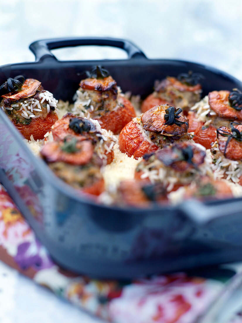 Baked tomatoes stuffed with pork and veal on a bed of rice