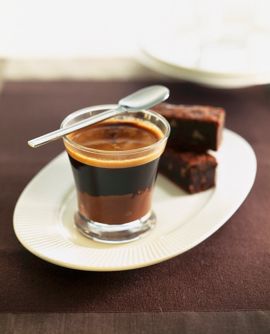 Glastasse mit Kaffee und Brownie