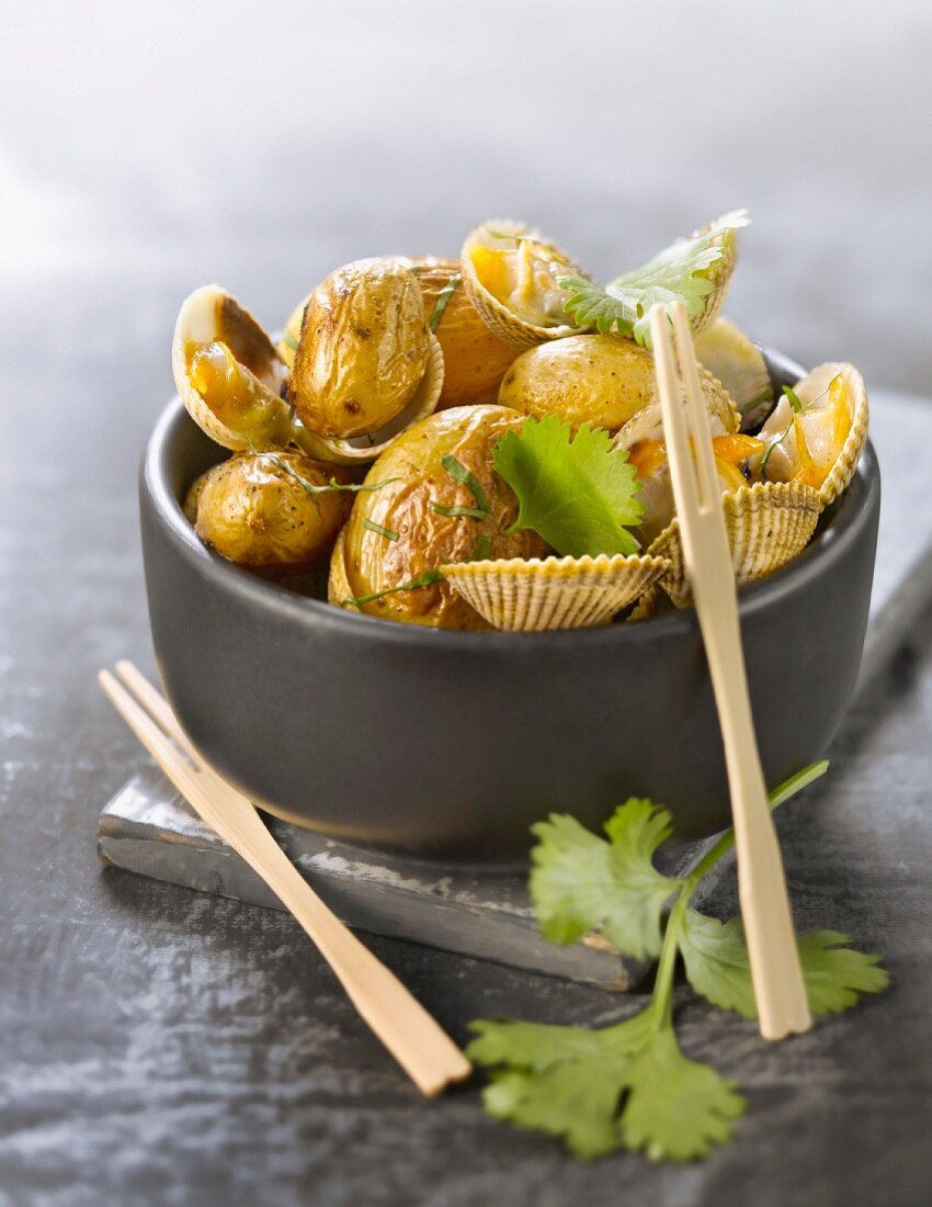 Roast ratte potatoes with cockles and coriander