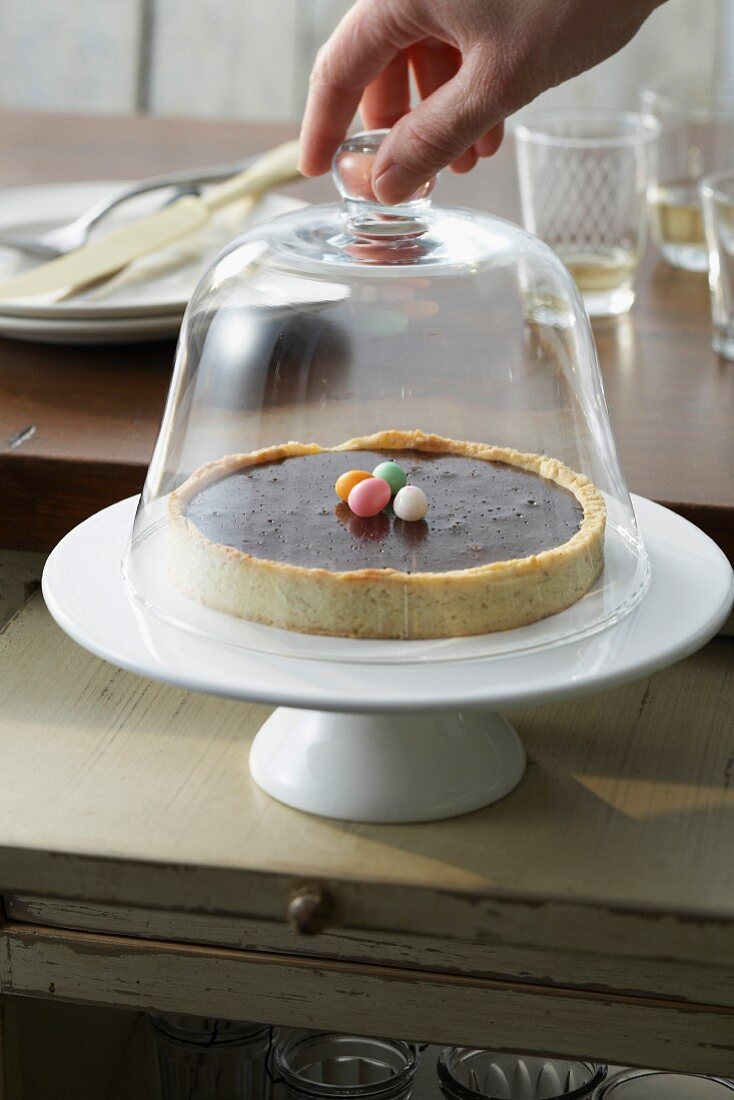 Chocolate tart under a glass dome