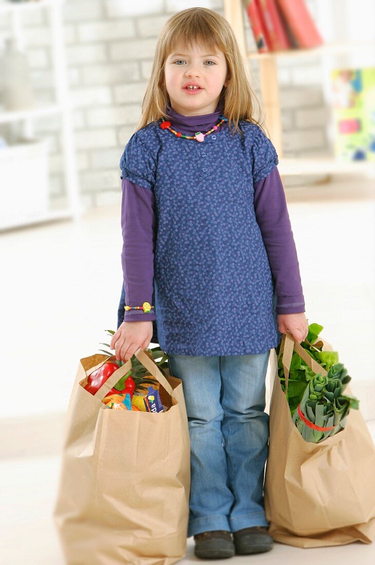 Young girl carrying bags of shopping