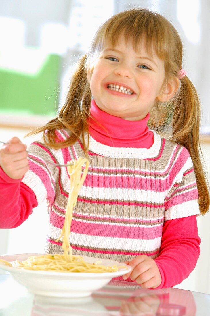Young girl enjoying a plate of pasta