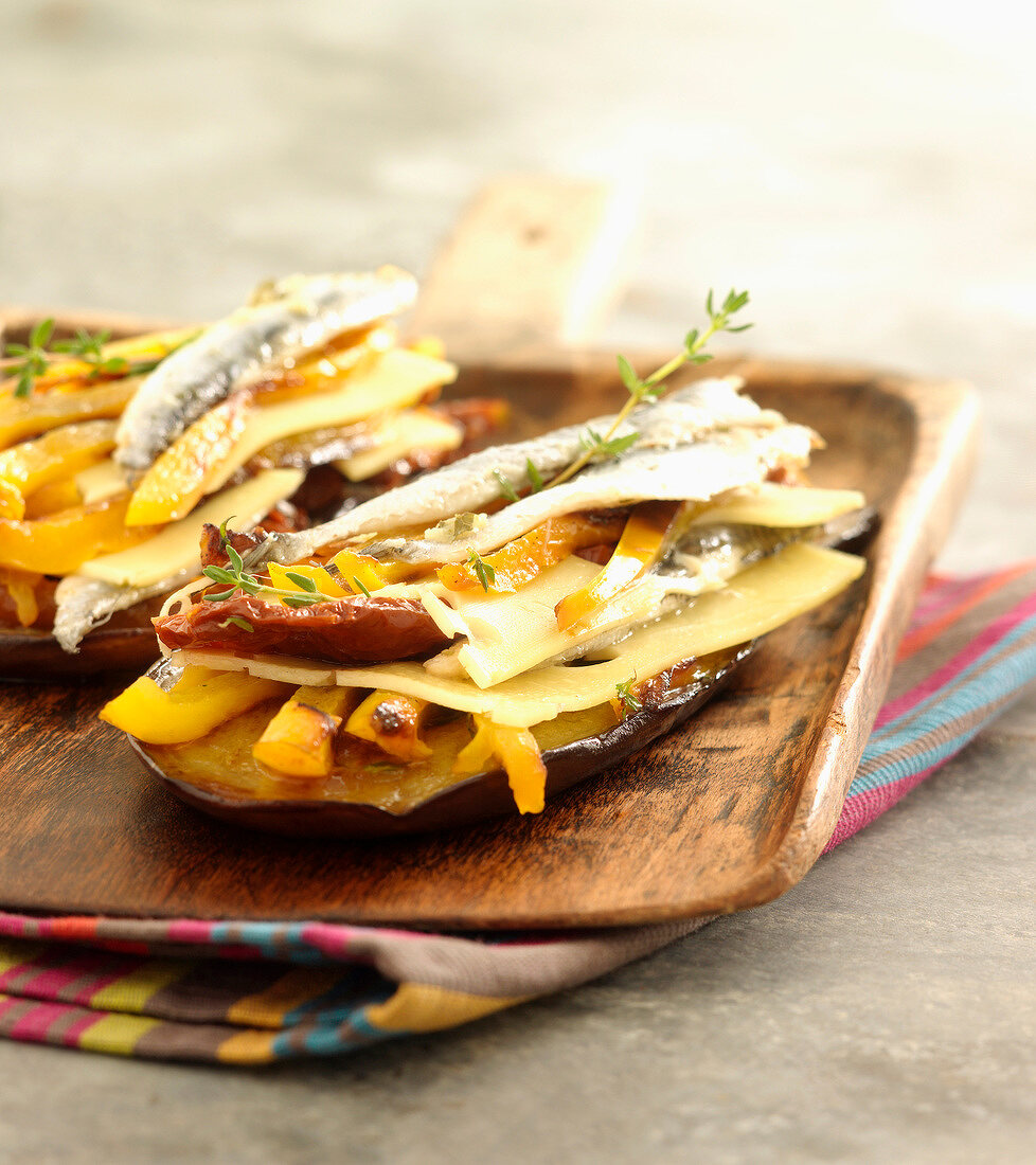 Sliced eggplant with anchovies, gruyère and peppers