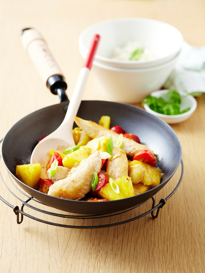 Chicken,cherry tomatoes and pineapple cooked in a wok