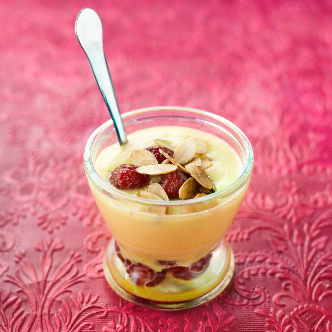 Peach cream dessert with raspberries and thinly sliced almonds