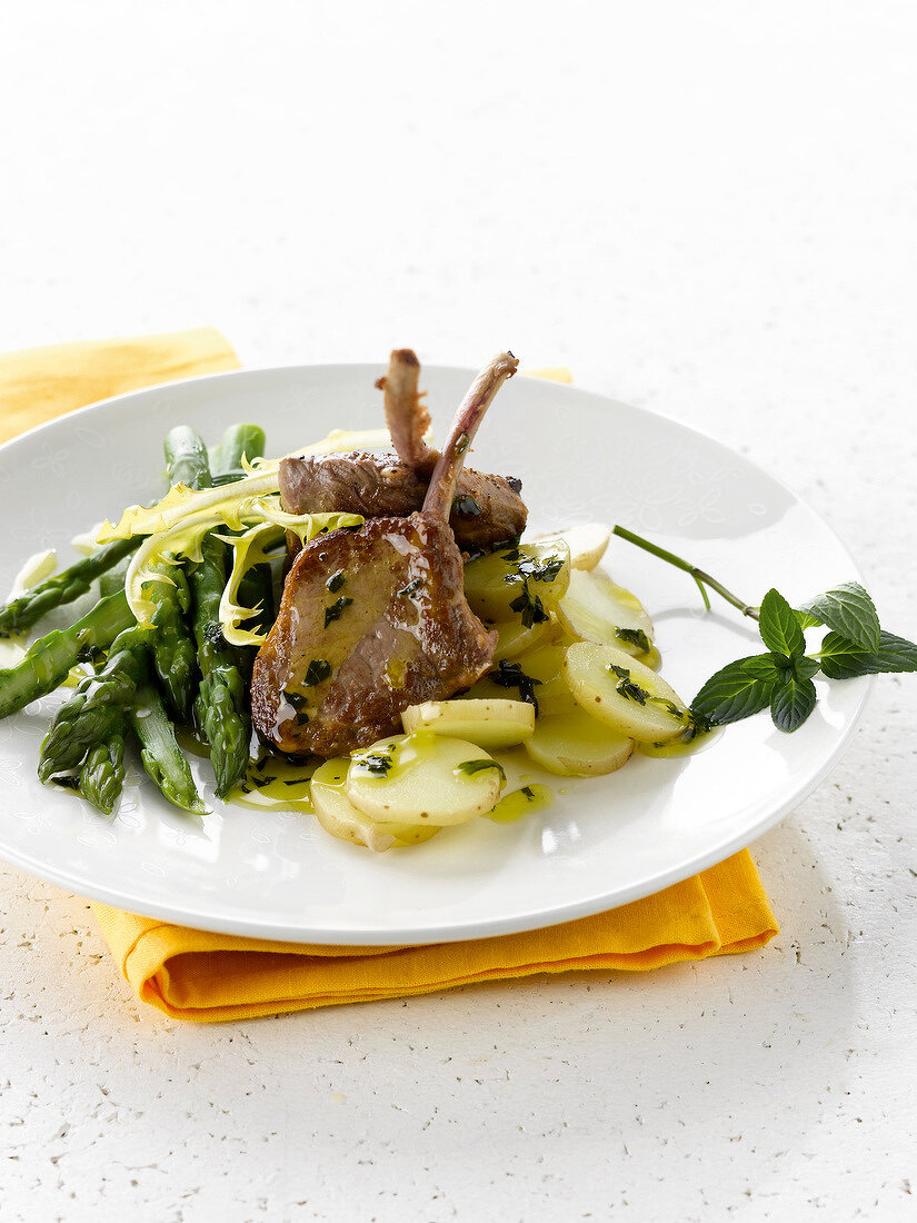 Lamb chops with potatoes and green asparagus with herbs