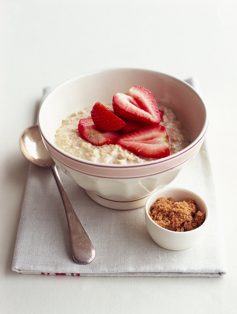Bowl of porridge with brown sugar and strawberries