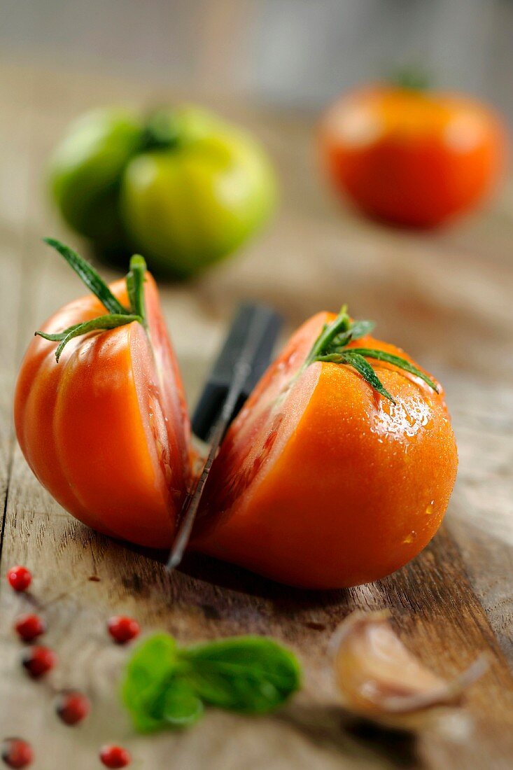 Eine halbierte Tomate mit Messer