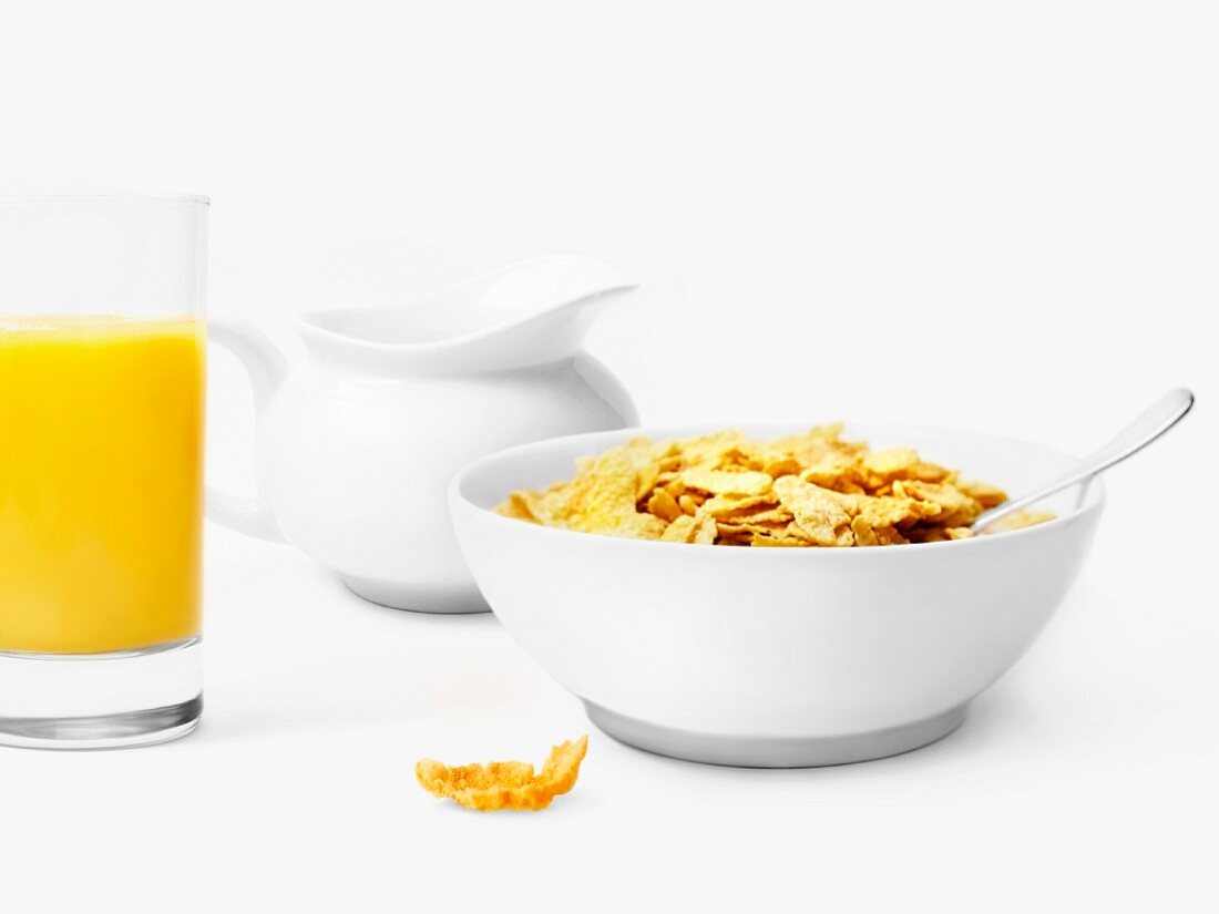 Eine Schale mit Cornflakes und ein Glas Orangensaft