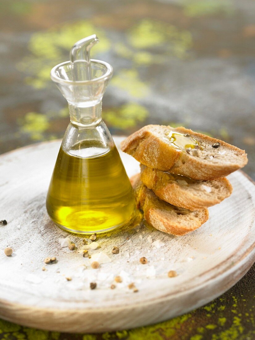 Weißbrot, ein Fläschchen Olivenöl und Pfefferkörner