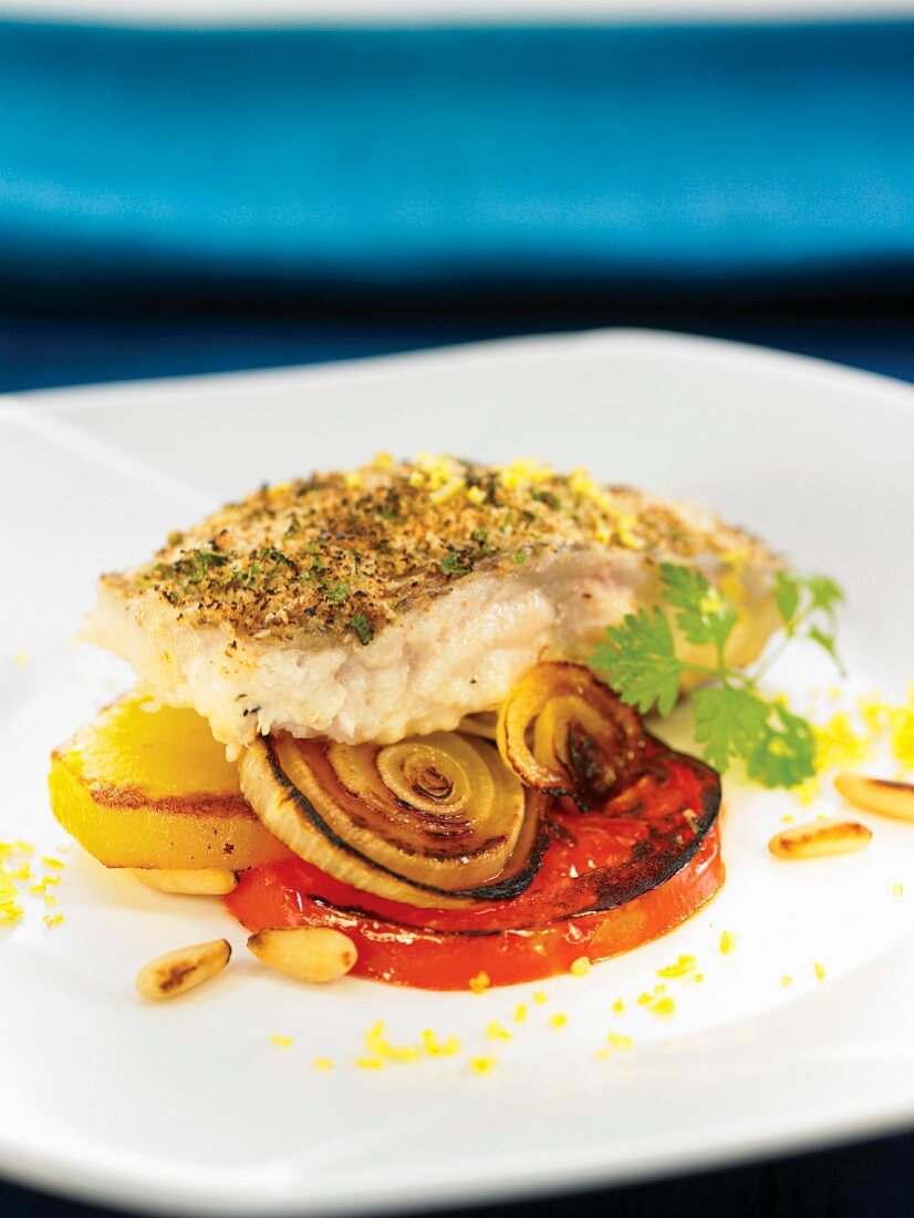 Oven-baked seabream coated in breadcrumbs, pan-fried tomatoes and onions