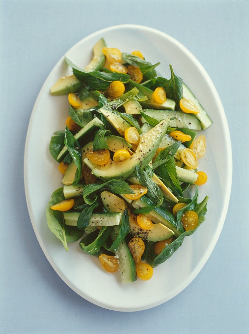 Salat mit Avocado, Gurken, gelben Kirschtomaten und Minze