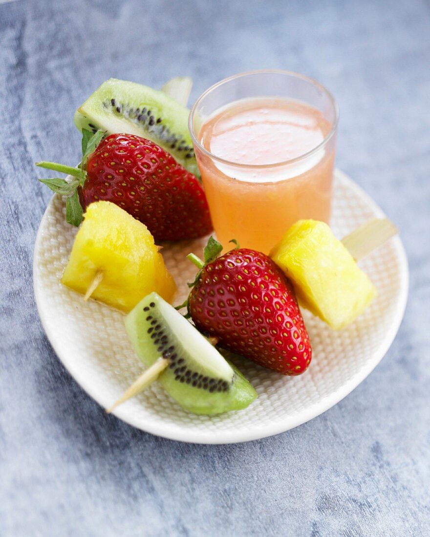 Obstspiesse und Glas Grapefruitsaft