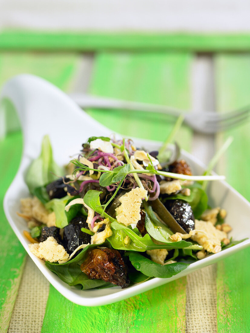 Mixed lettuce salad with cheese and prunes