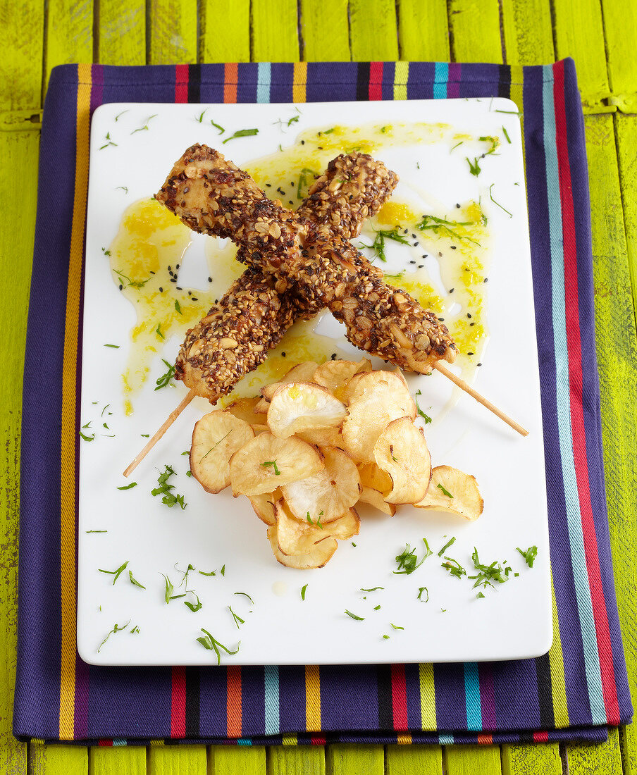 Chicken brochettes coated with seeds and homemade crisps