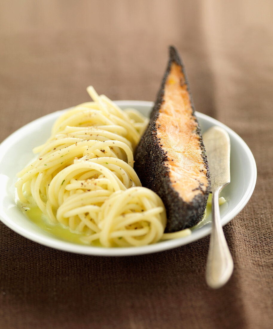 Piece of salmon in poppyseed crust and spaghettis with coriander juice