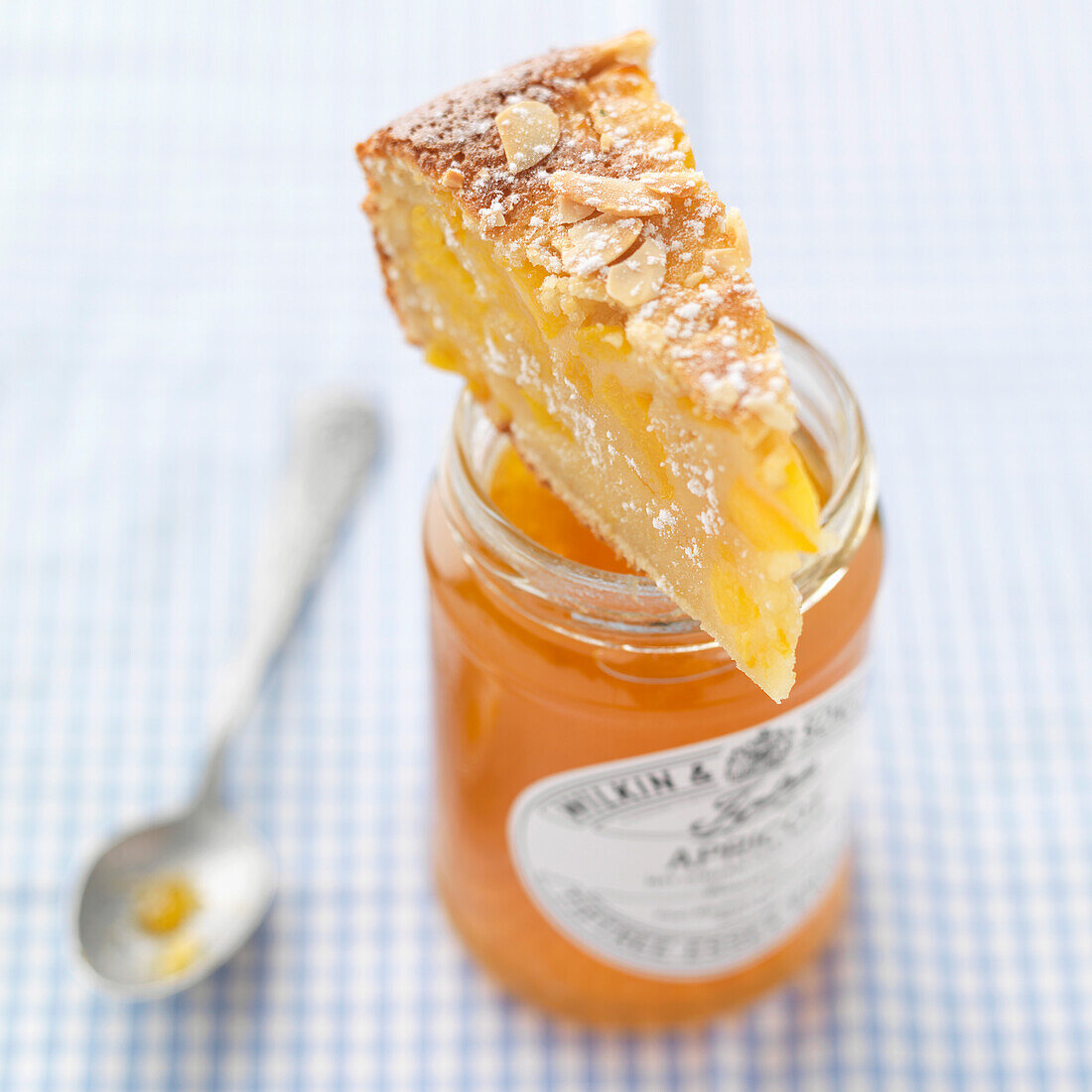 Ein Stück Pfirsich-Mandel-Clafoutis auf Marmeladeglas