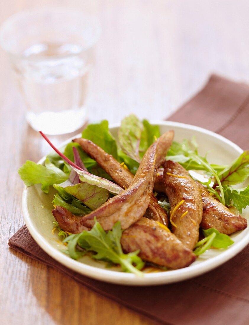 Sliced duck breast with orange and mixed lettuce salad
