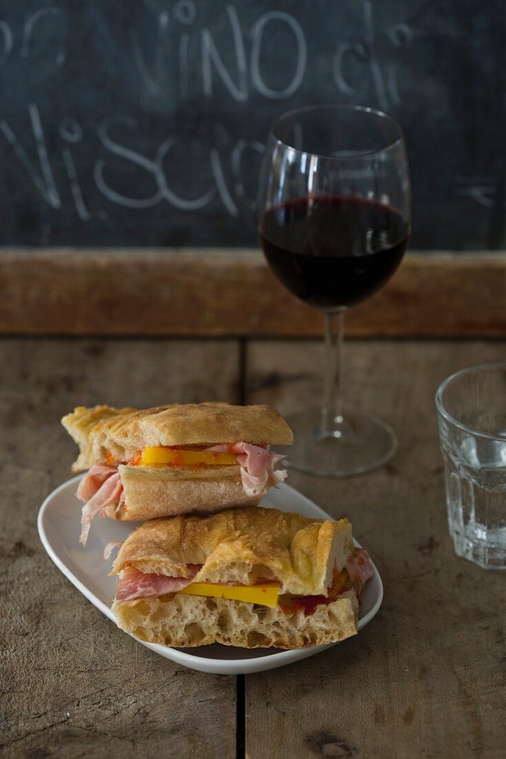 Rohschinken-Käse-Sandwich und Glas Rotwein