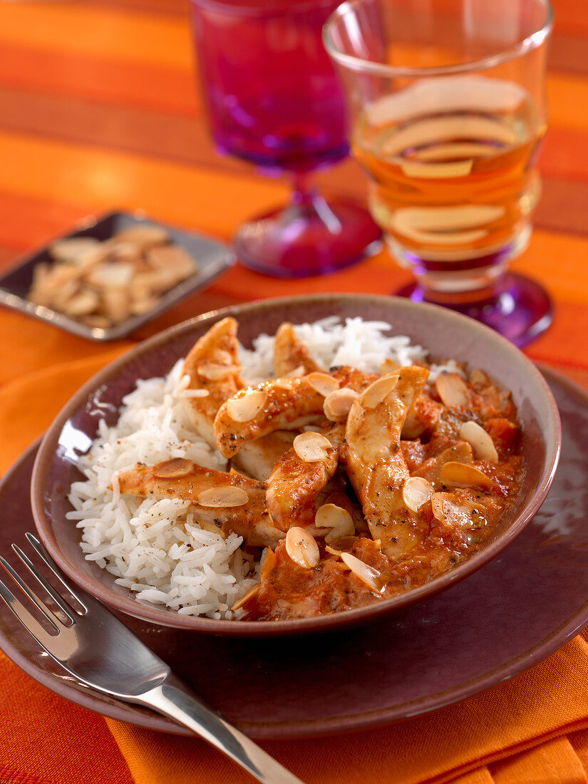 Sliced chicken breasts with almond sauce and rice