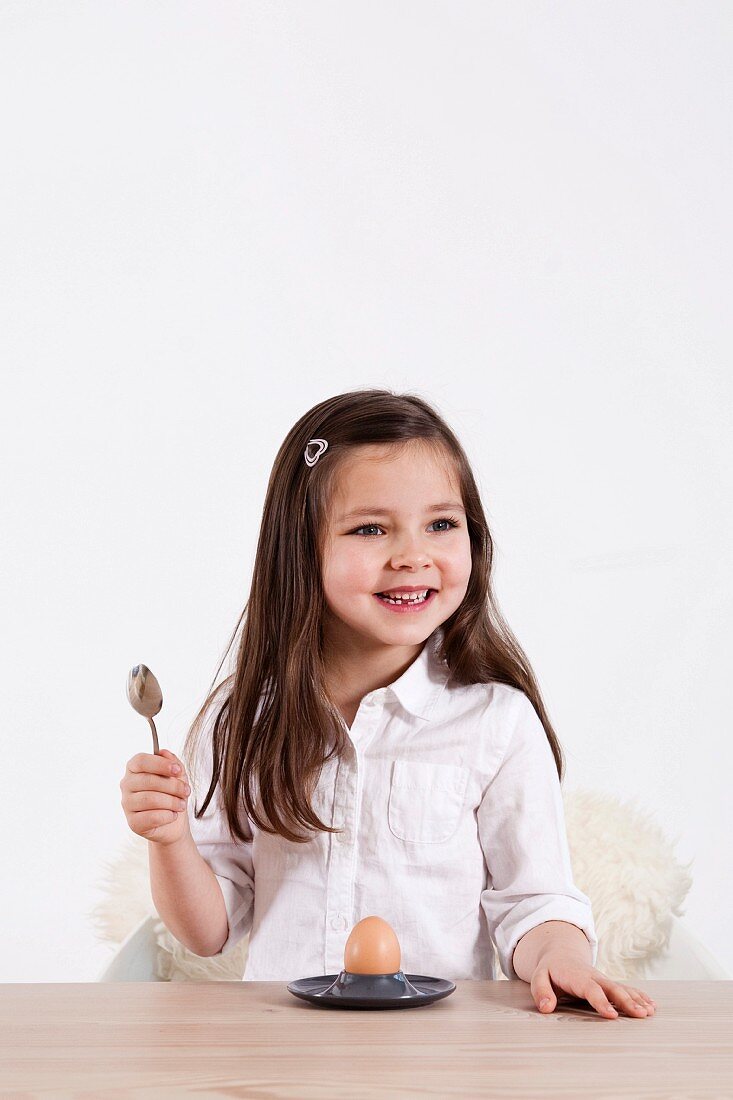 Young girl eating a soft-boiled egg