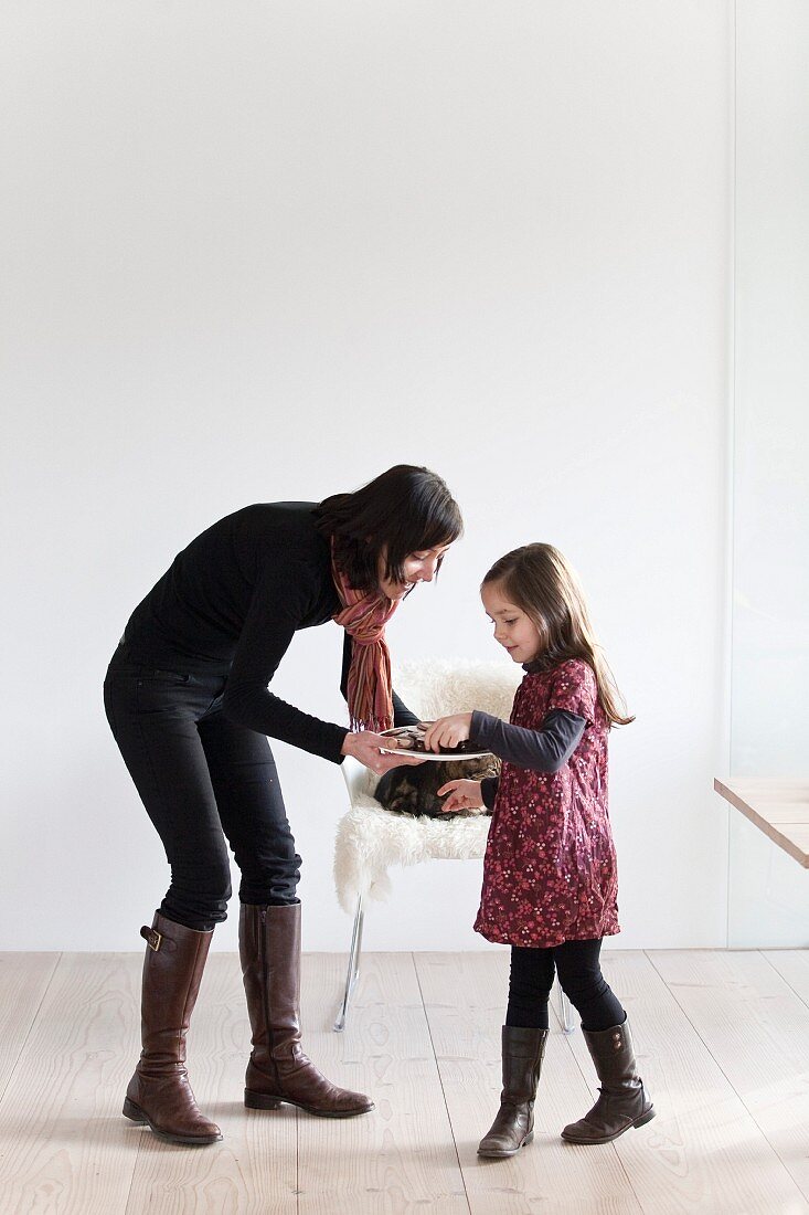 Frau bietet kleinem Mädchen Teller mit Schokoplätzchen an