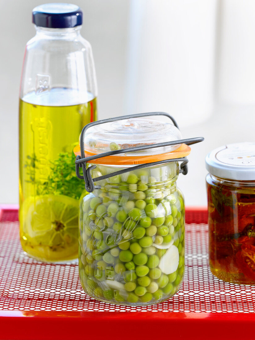 Jar of peas with horseradish,bottle of oil with thyme and lemon