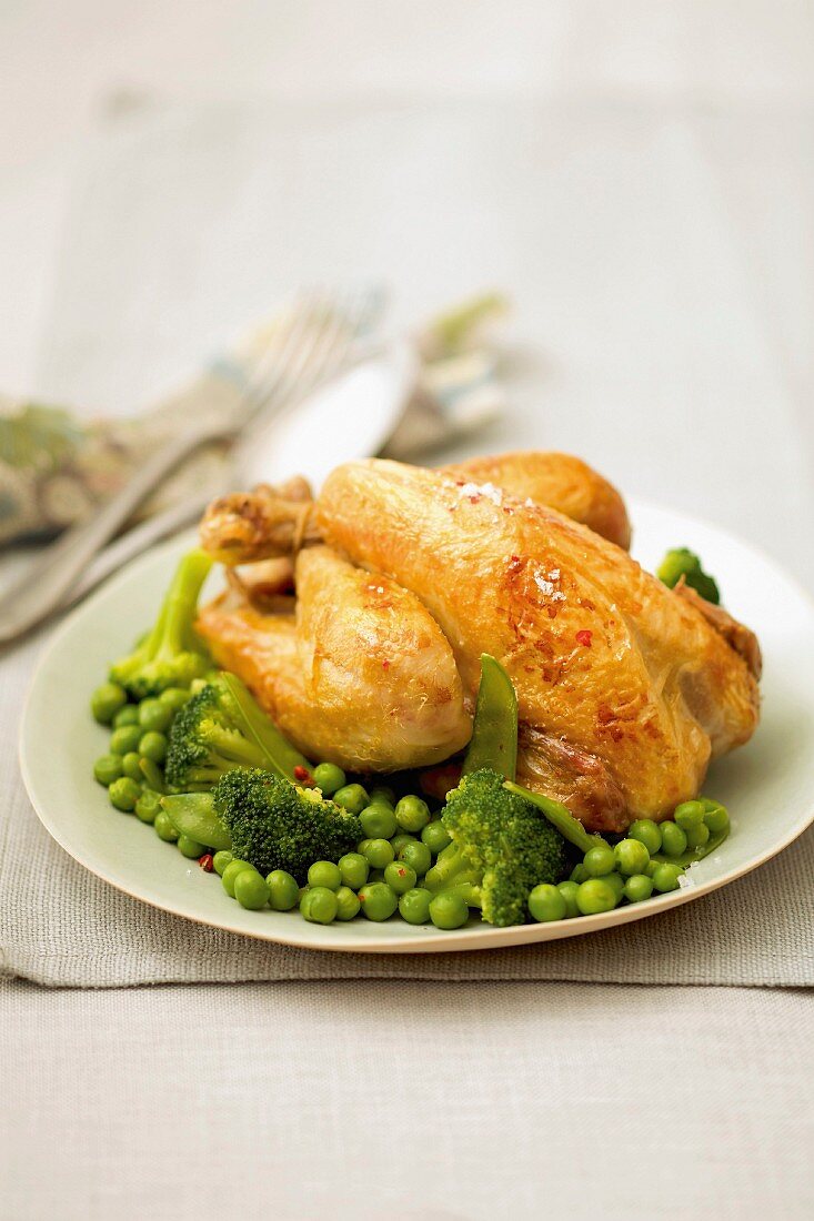 Young cockerel with peas, broccolis and sugar peas