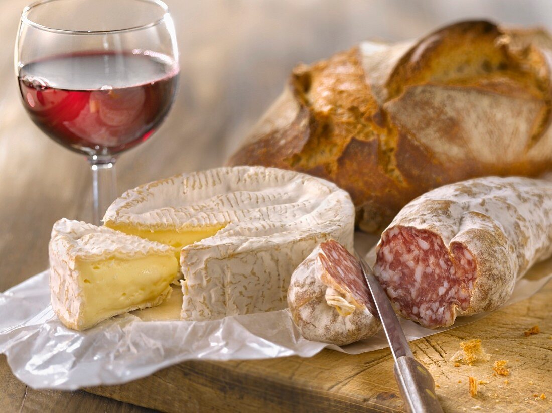 Camembert, dried sausage, bread and a glass of red wine