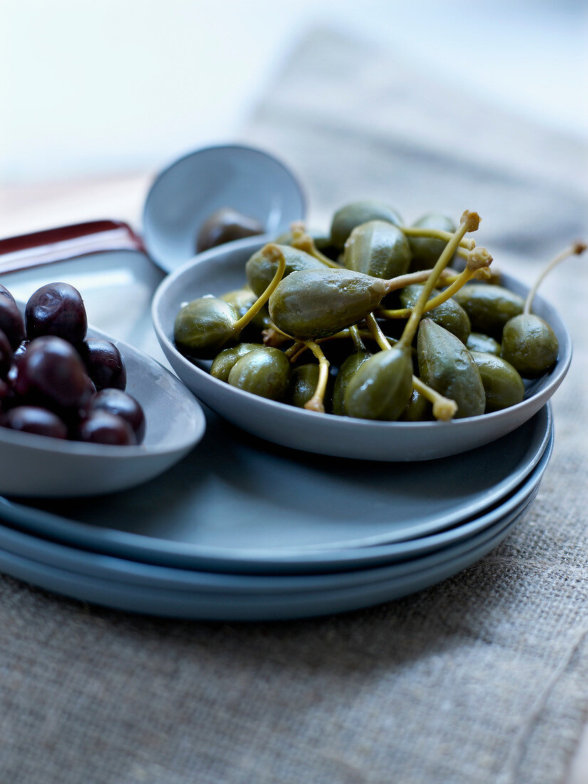 Kapernäpfel und Oliven in Schalen