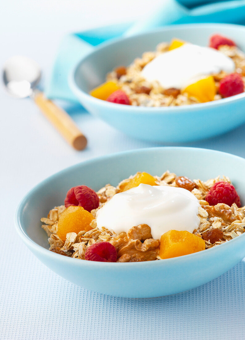 Müsli im Schälchen mit Obst, Nüssen und Joghurt