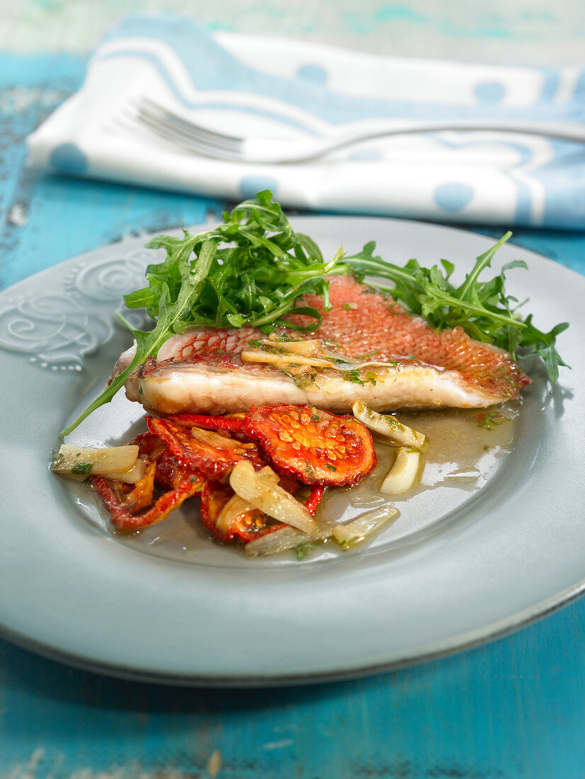 Doradenfilet mit Tomatenconfit, Rucola und Knoblauch