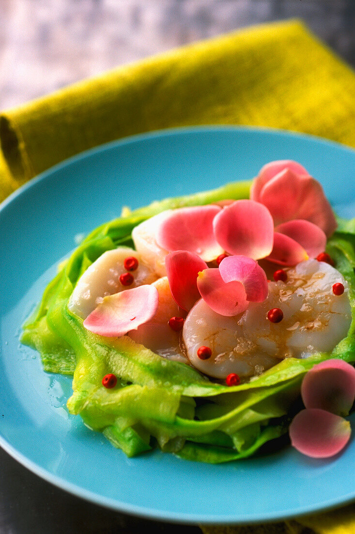 Scallops with rose petals on a bed of zucchinis