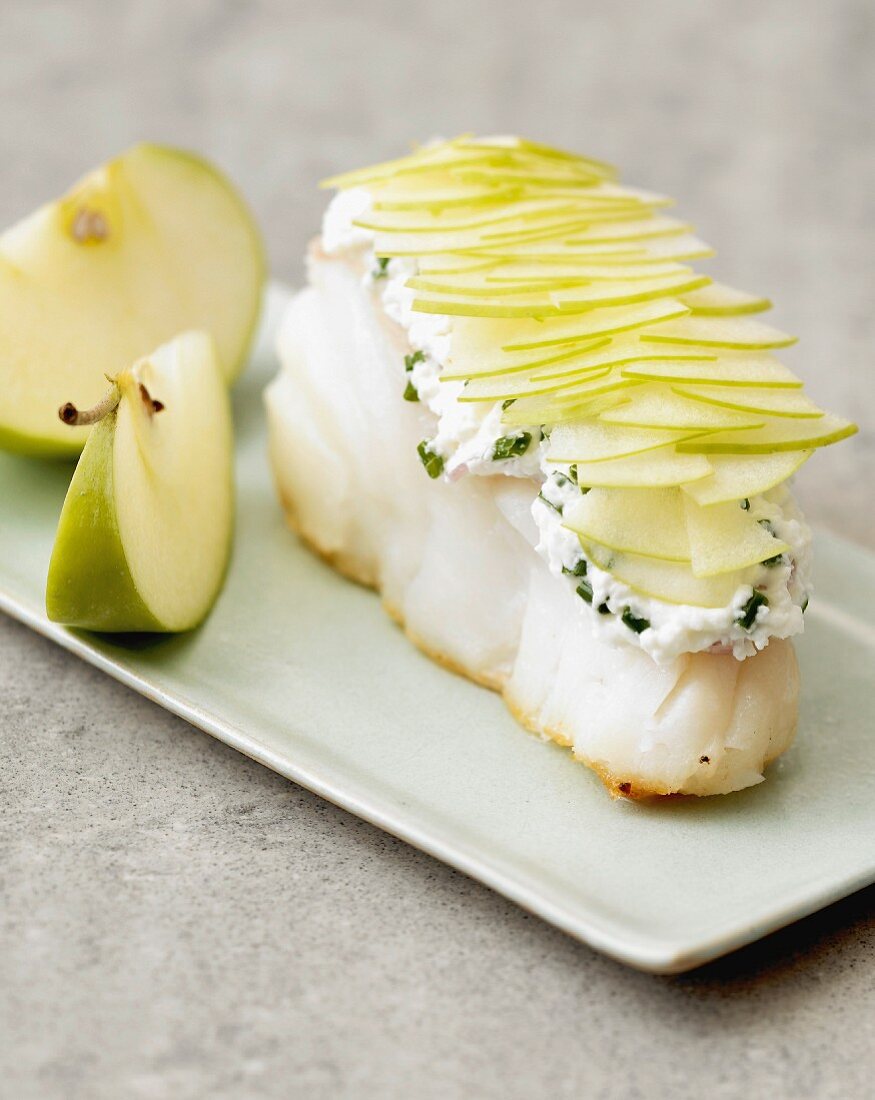 Piece of cod topped with fromage frais with herbs and potato scales
