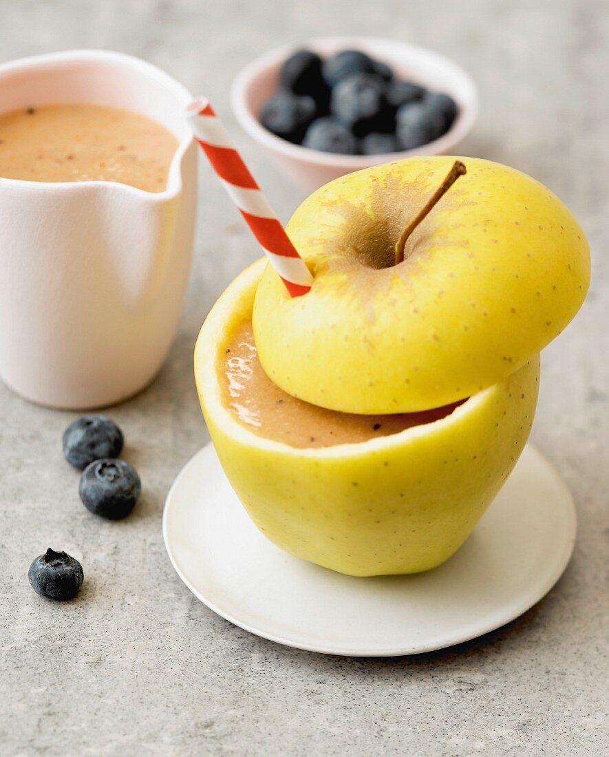 Apfel-Karotten-Heidelbeer-Smoothie in ausgehöhltem Golden Delicious