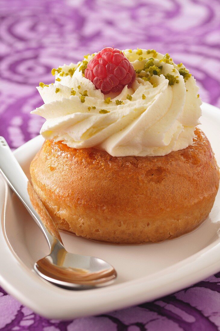 Baba au rhum mit Schlagsahne, Himbeeren und Pistazien