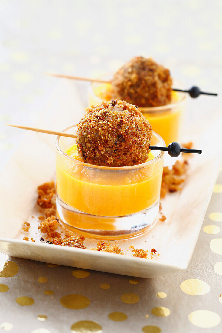 Cream of carrot soup with foie gras balls coated in crumled gingerbread