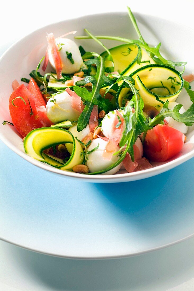 Salat mit Rucola, Zucchini, Tomaten, Mozzarella und Rohschinken
