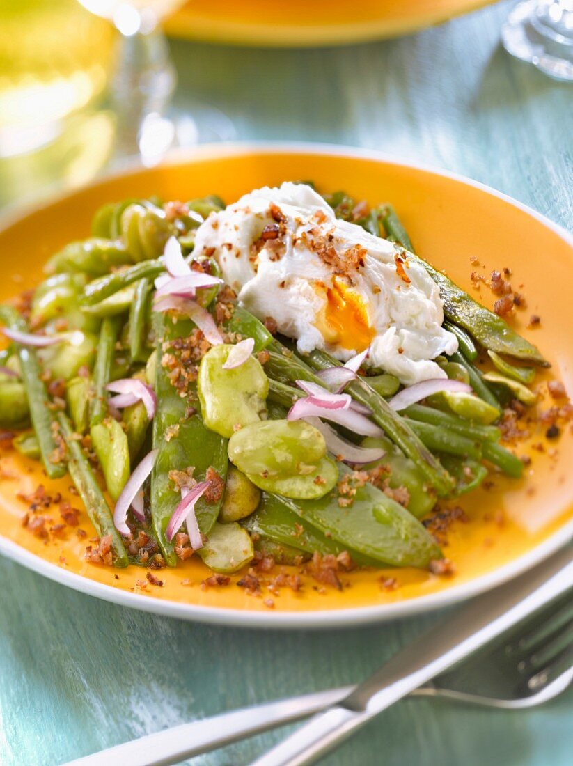 Pan-fried fava beans,sugar peas and green beans with a poached egg and breadcrumbs