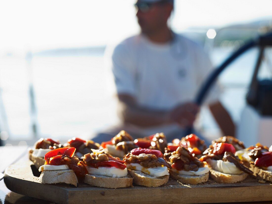 Peppers and cheese on sliced bread :appetizers on a boat