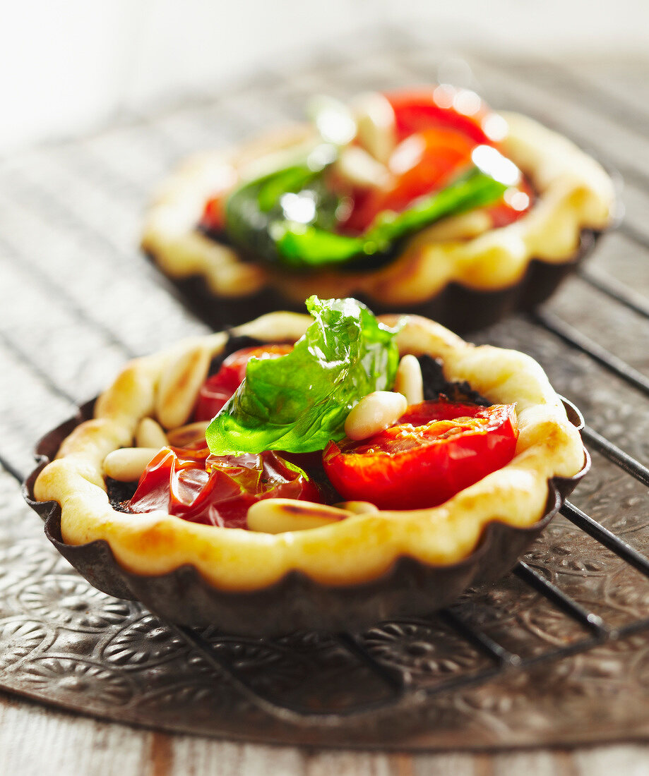 Zwei Tartelettes mit Kirschtomaten, Tapenade und Pinienkernen