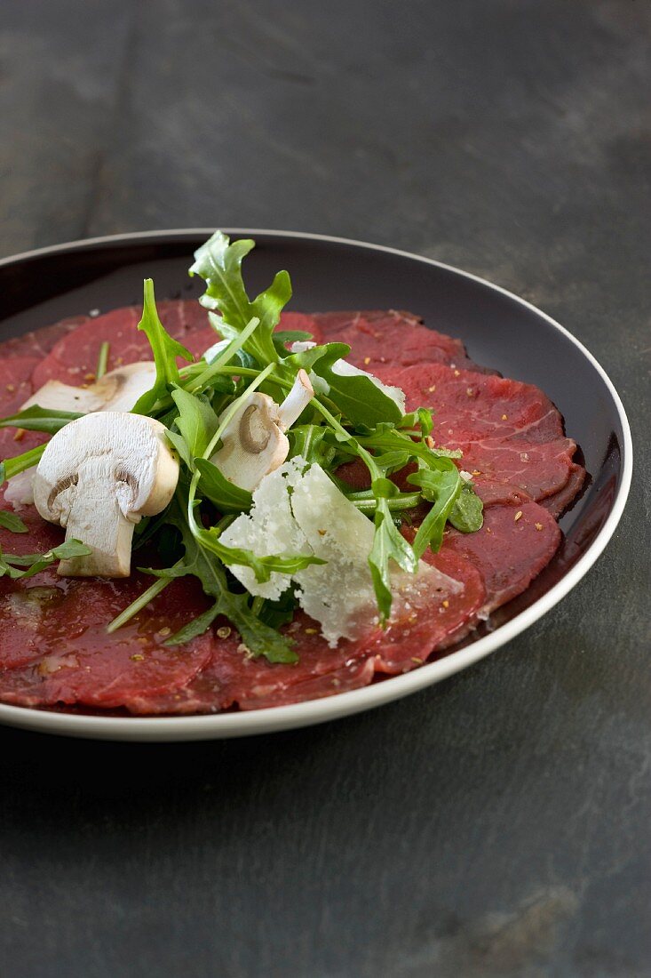 Beef carpaccio with rocket lettuce, mushrooms and parmesan