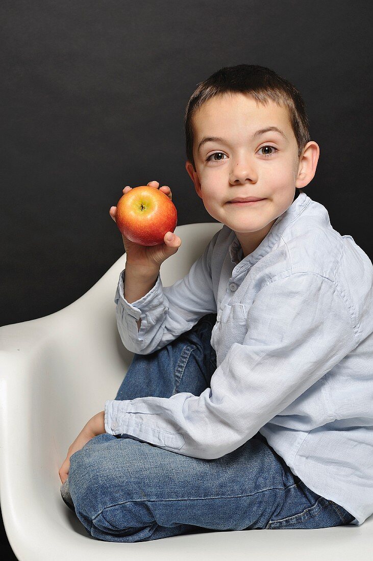 Young boy holding an apple