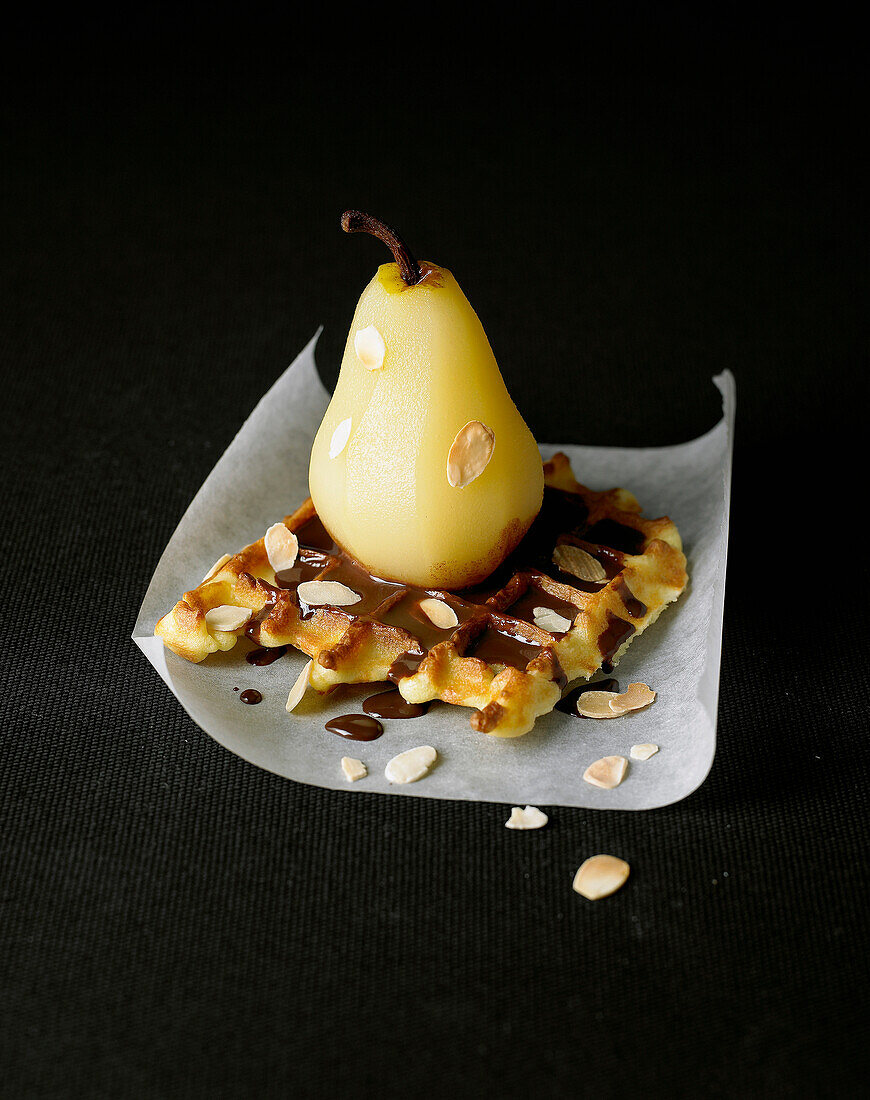 Waffle with poached pear,thinly sliced almonds and chocolate sauce