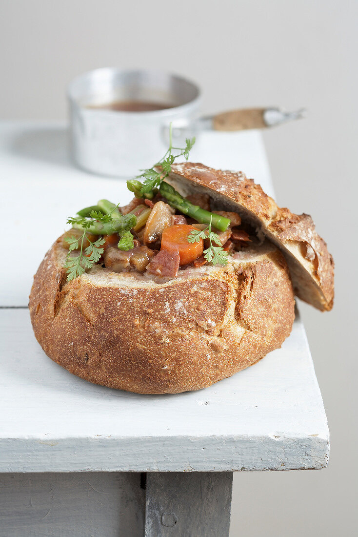 Stewed vegetables served in a round loaf of bread