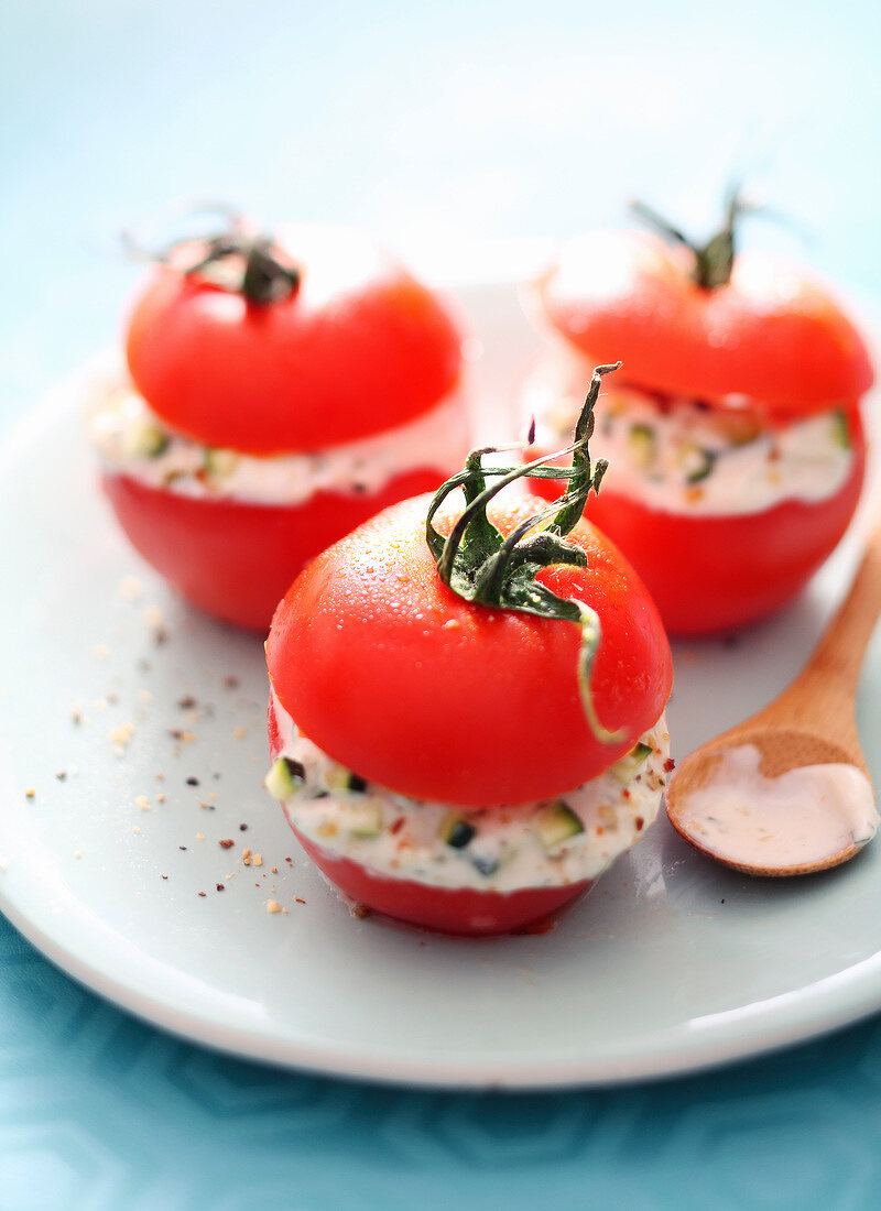 Raw tomatoes stuffed with cheese and zucchinis