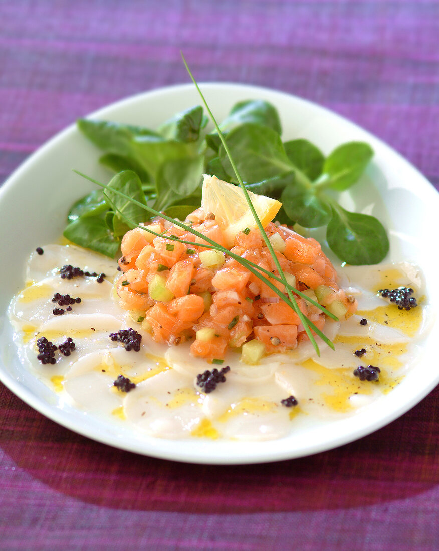 Salmon tartare on a bed of thinly sliced scallops